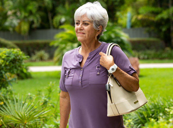Senior lady walking wearing a medical alert system